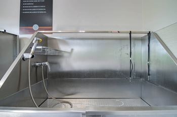 A shower in a stainless steel room 